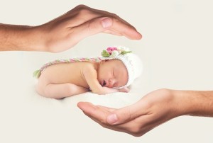 le mani cercano di proteggere un neonato