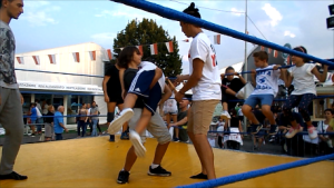 Bambini sul ring provano a caricare una bodyslam sotto lo sguardo attento dei maestri